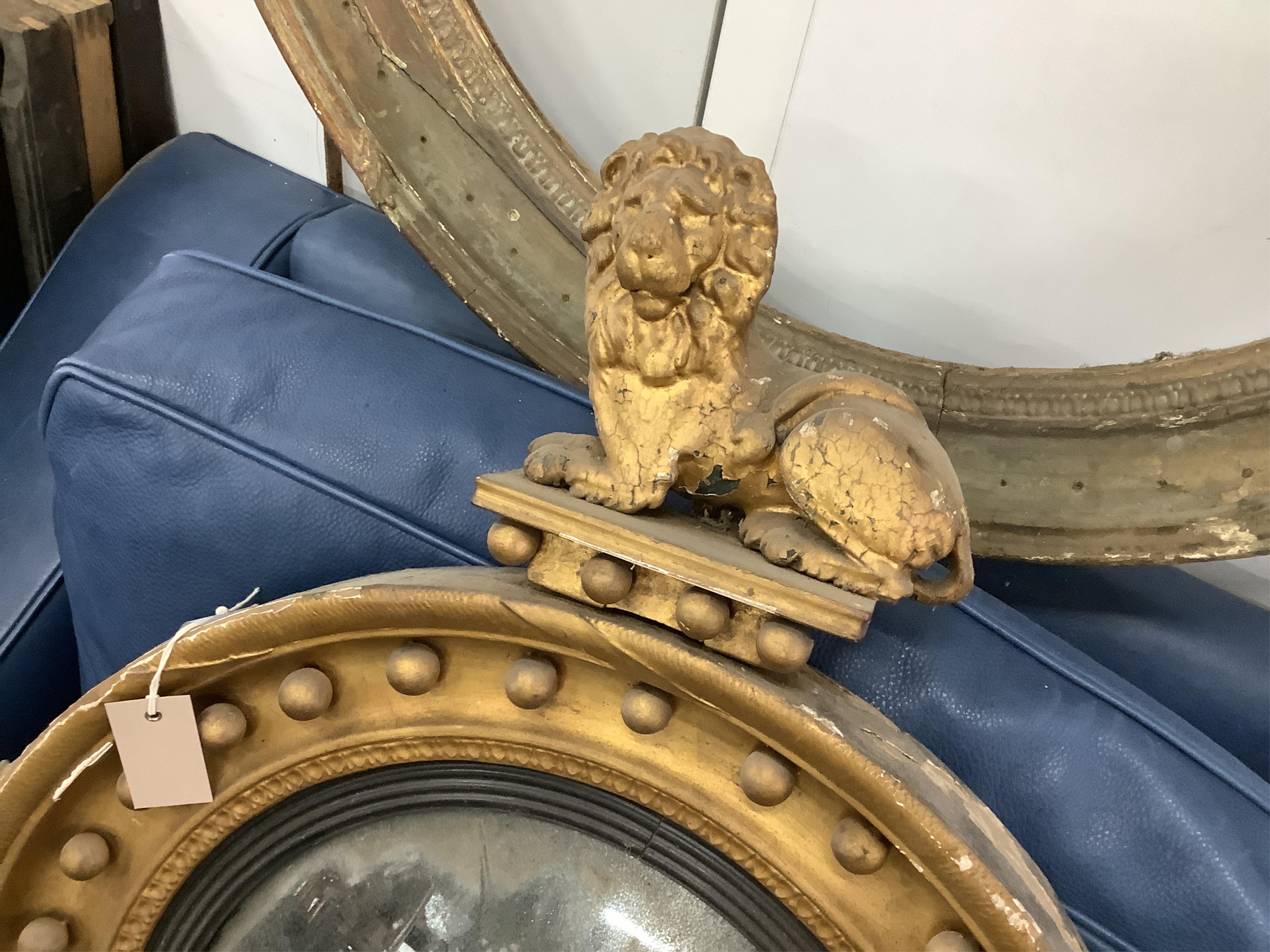 A Regency circular giltwood convex wall mirror with lion pediment, diameter 65cm a Regency convex mirror frame and Victorian girandole. Condition - poor